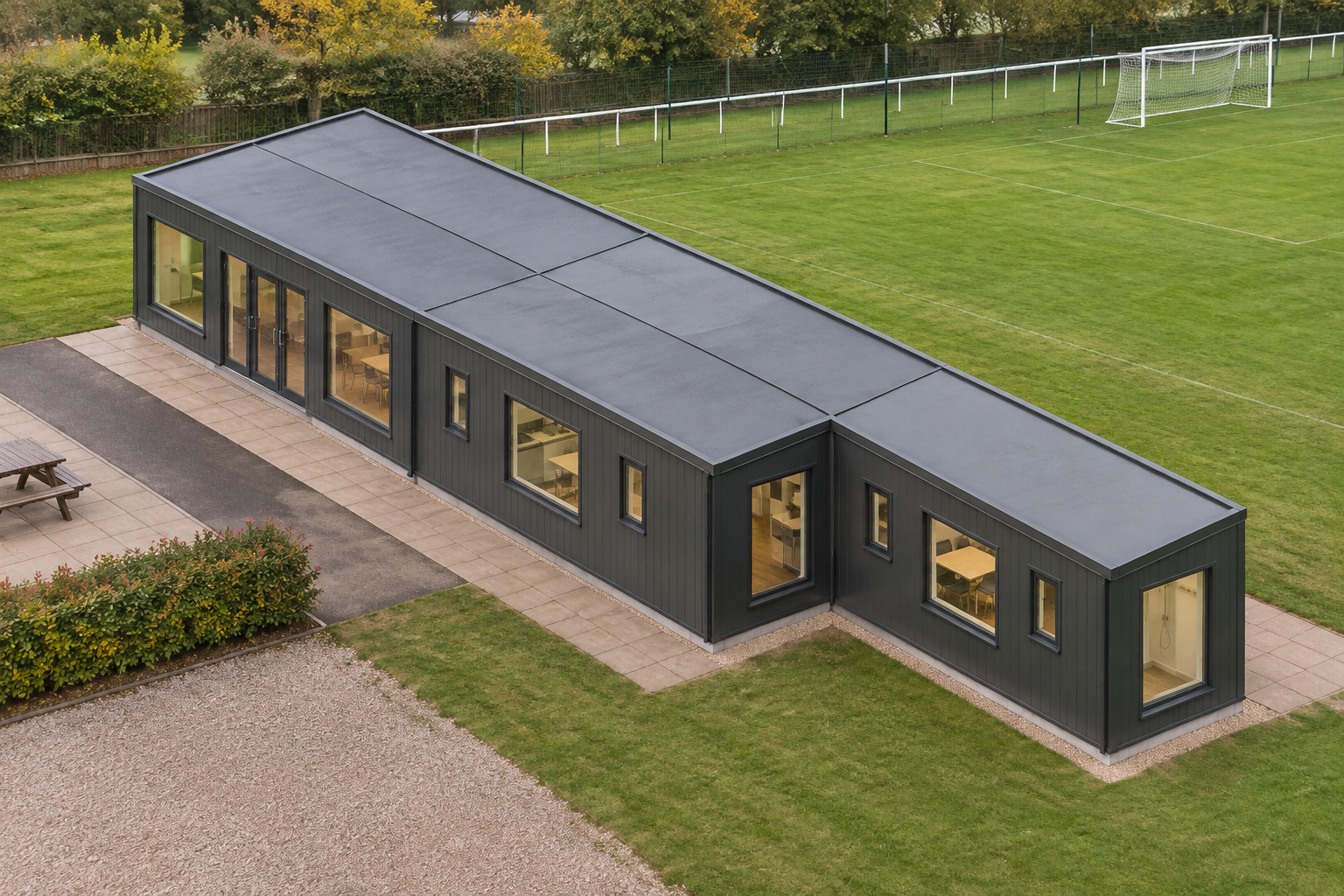 5-Module Clubhouse with Kitchenette, WC and Shower Anthracite Grey single-storey modular clubhouse beside a community sports ground.